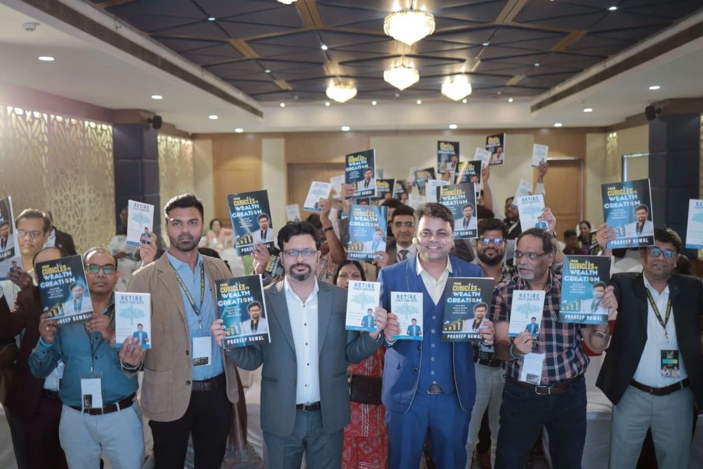 Pradeep Rawal and participants holding copies of his book From Cubicles to Wealth Creation at its launch